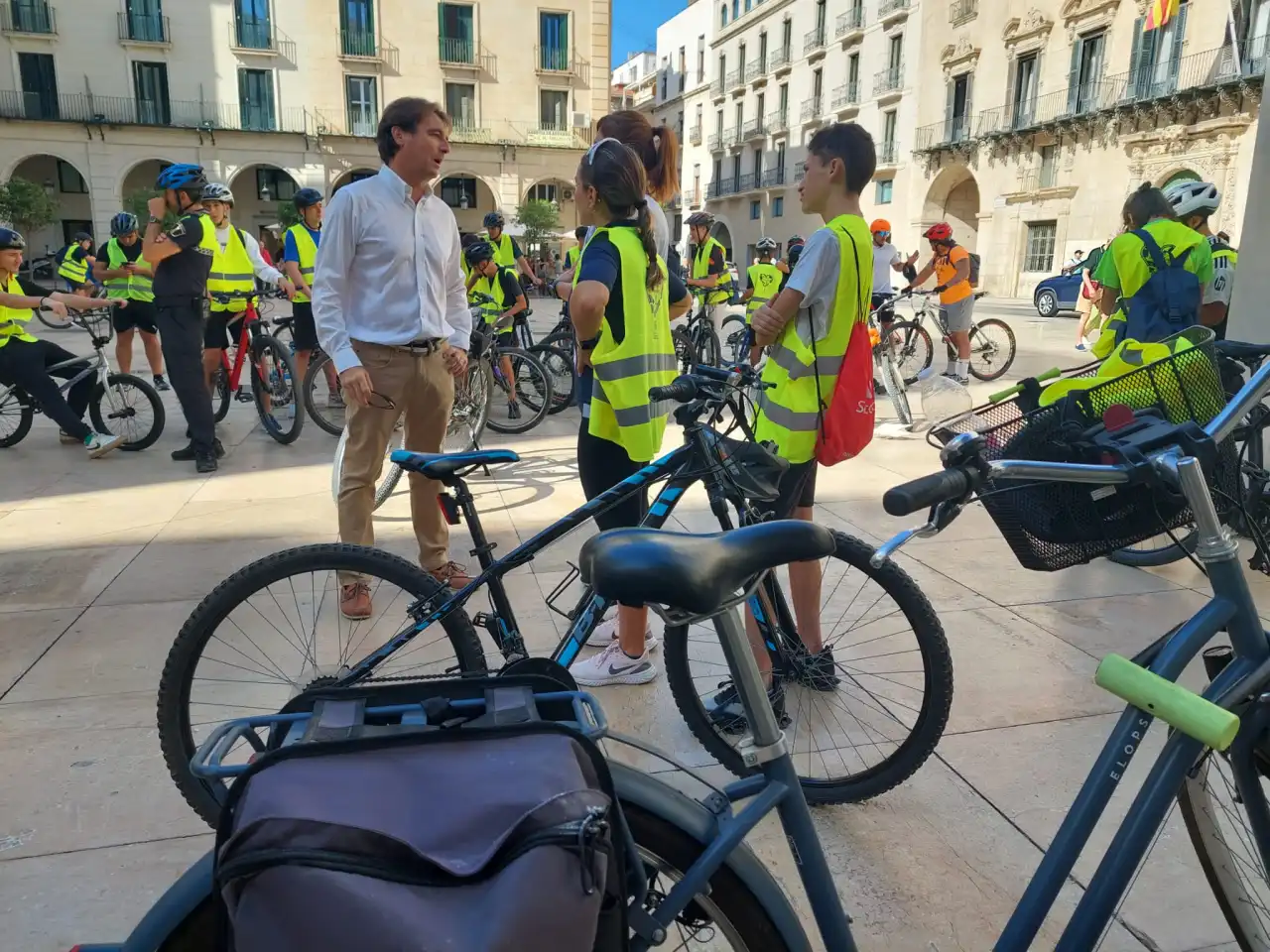 Jóvenes con chalecos reflectantes y bicicletas en la Plaza del Ayuntamiento